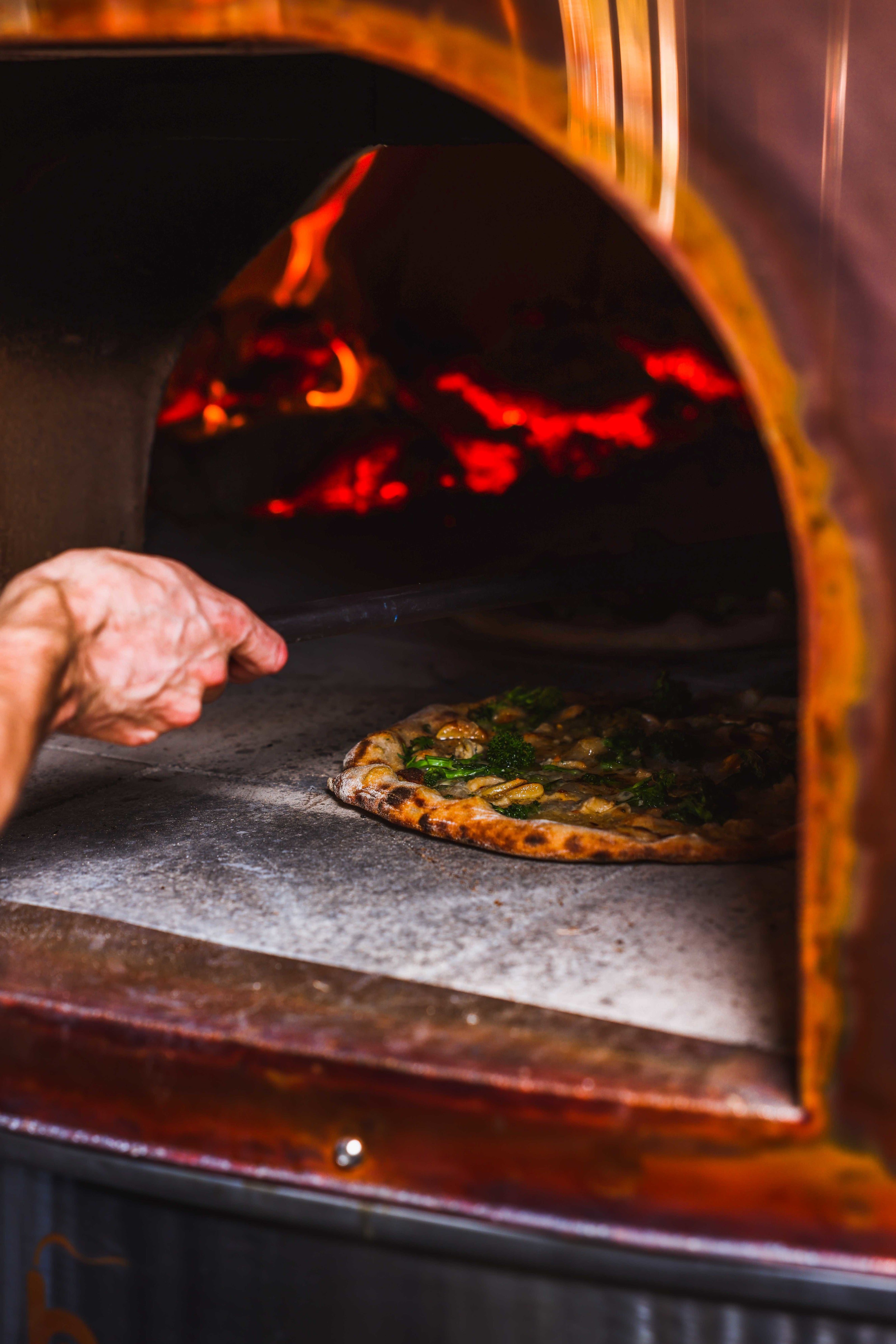 Pizza coming out the oven