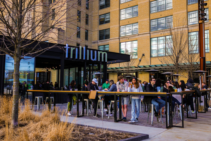 A crowded patio scene outside Trillium Fenway with heat lamps