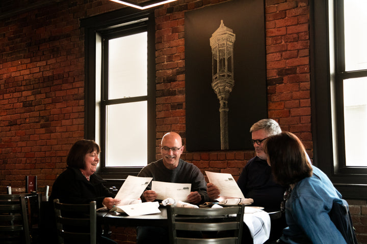 A group of four explores the menu in the upstairs restaurant space at Trillium Fort Point