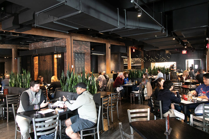Guests dining in a busy restaurant scene at Trillium Fort Point
