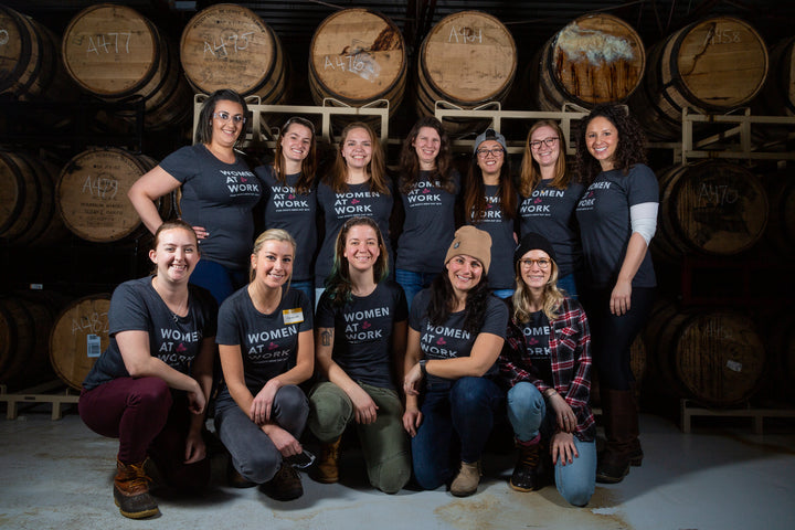 Group shot of the women of team Trillium in front of barrels